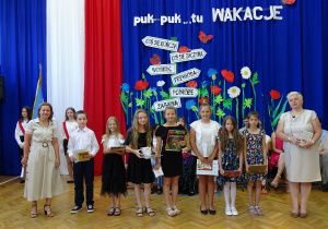 dzieci stojące z nagrodami oraz nauczyciele