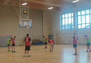 chłopcy grający w koszykówkę w sali gimnastycznej